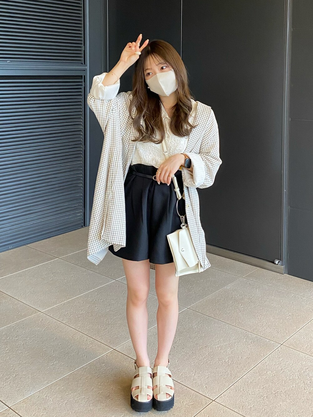 ブラック系のパンツ、ホワイト系のTシャツ/カットソー、ベージュ系のショルダーバッグを着用したレディースの春コーディネートの3枚目の写真