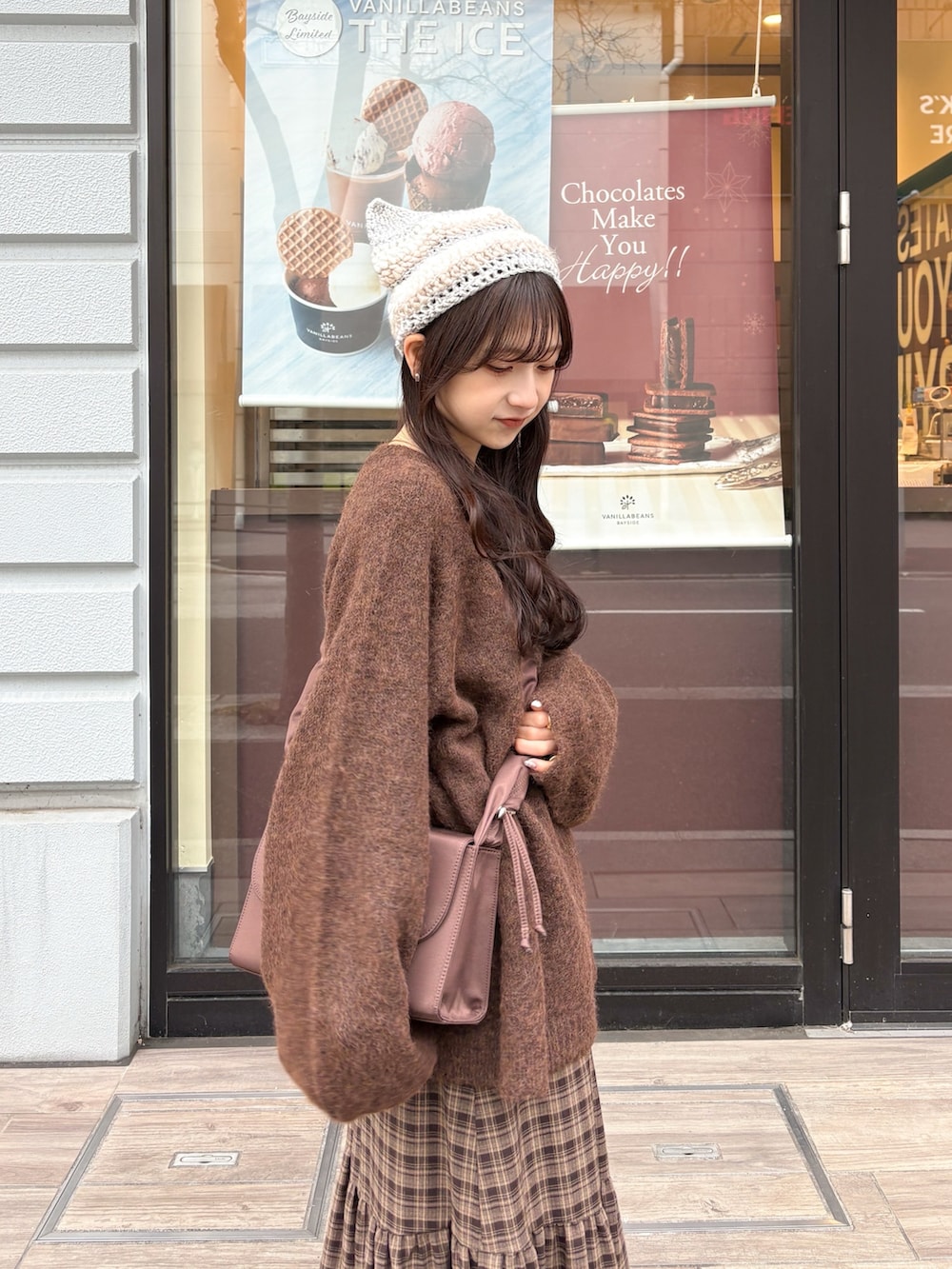 ブラウン系のニット/セーター、ブラウン系のスカート、ホワイト系のその他アウターを着用したレディースの冬コーディネートの3枚目の写真