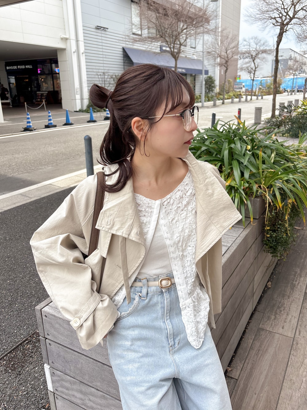 ホワイト系のトレンチコート、ホワイト系のシャツ/ブラウス、ブルー系のデニムパンツを着用したレディースの春コーディネートの4枚目の写真