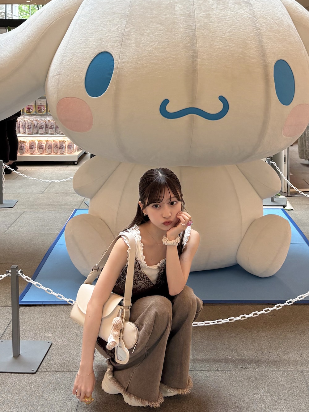 ホワイト系のタンクトップ、ブラウン系のデニムパンツ、ブラウン系のキャミソールを着用したレディースの夏コーディネートの4枚目の写真