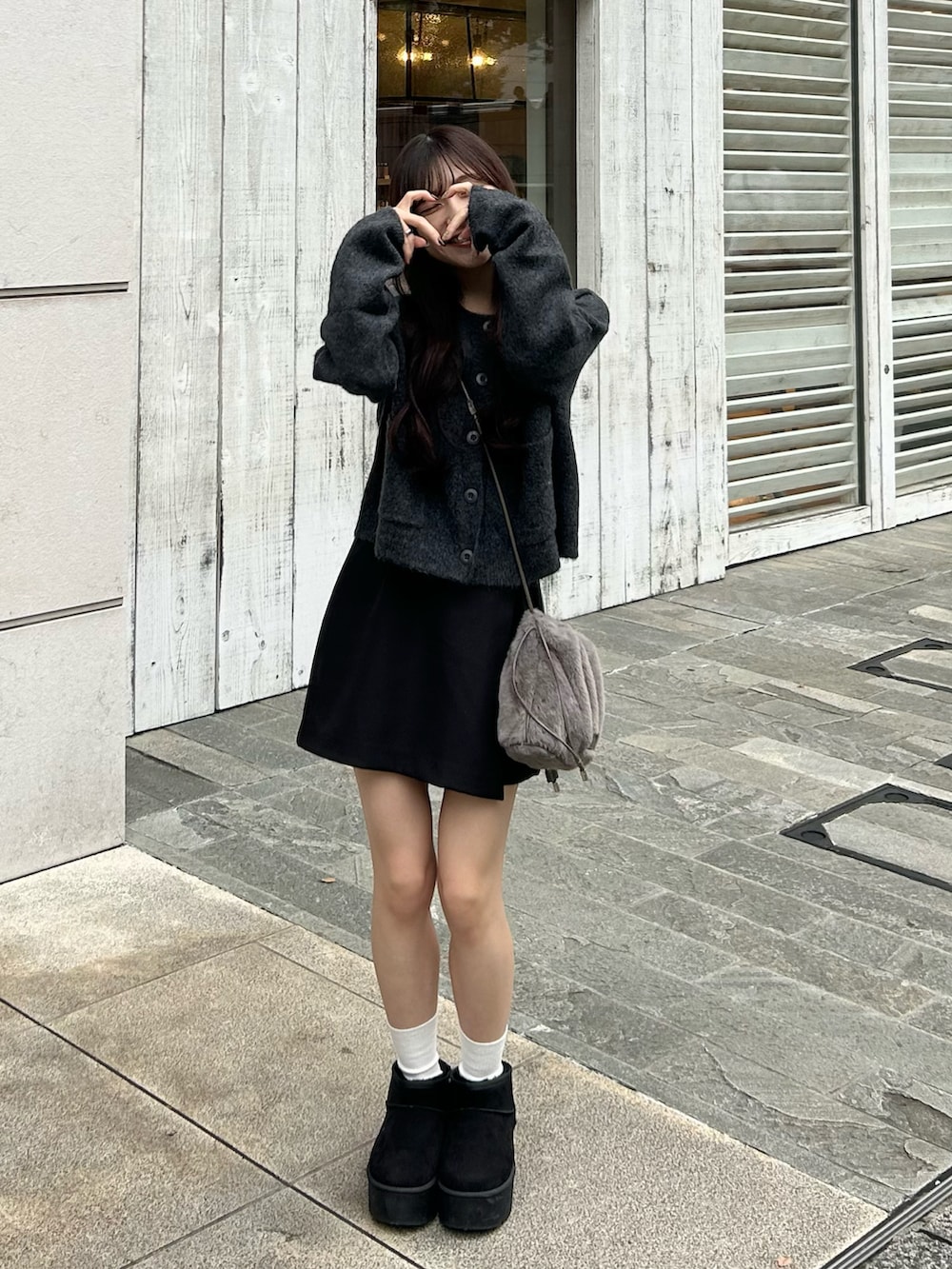 ブラック系のブーツ、グレー系のニット/セーター、ブラック系のスカートを着用したレディースの秋コーディネートの4枚目の写真