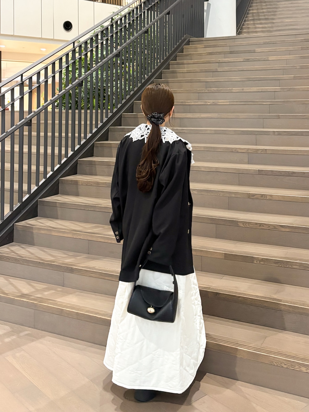 ホワイト系のニット/セーター、ブラック系のテーラードジャケット、ブラック系のブーツを着用したレディースの秋コーディネートの4枚目の写真