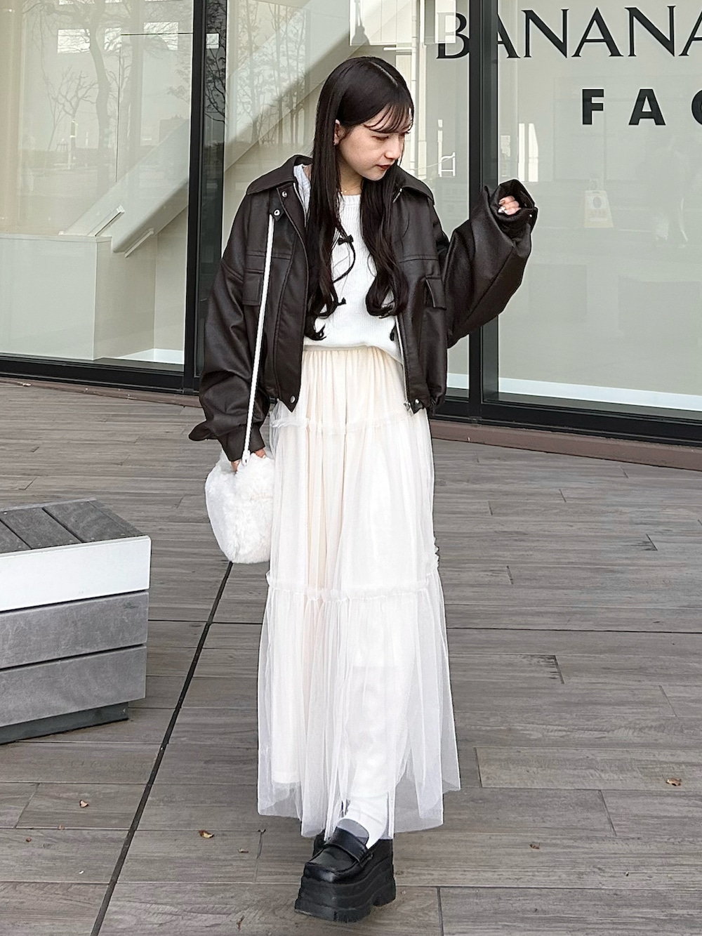 ブラウン系のジャケット/アウター、ホワイト系のハンドバッグ、ホワイト系のスカートを着用したレディースの冬コーディネートの3枚目の写真