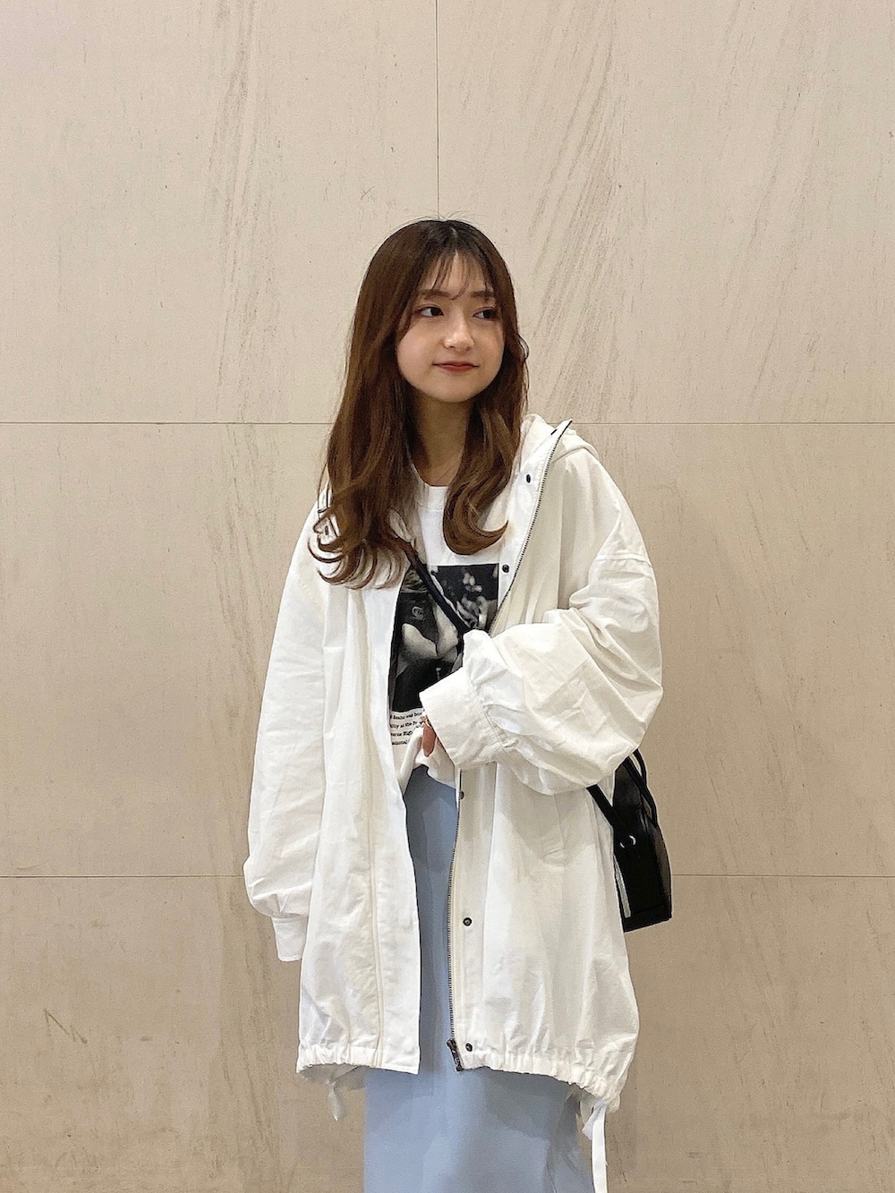 ホワイト系のスウェット、ホワイト系のスニーカー、ホワイト系のマウンテンパーカーを着用したレディースの春コーディネートの2枚目の写真