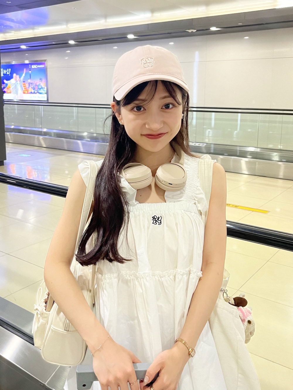 ホワイト系のトップス、ホワイト系のバッグ、ブルー系のパンツを着用したレディースの夏コーディネートの4枚目の写真