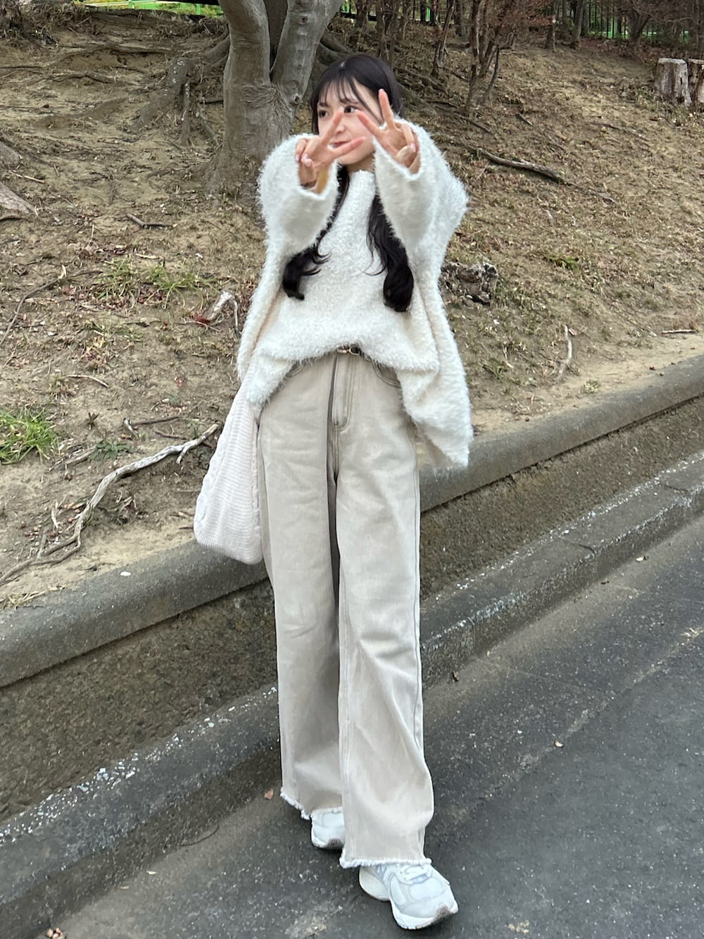 ベージュ系のデニムパンツ、ホワイト系のダッフルコート、ホワイト系のカーディガン/ボレロを着用したレディースの冬コーディネートの3枚目の写真