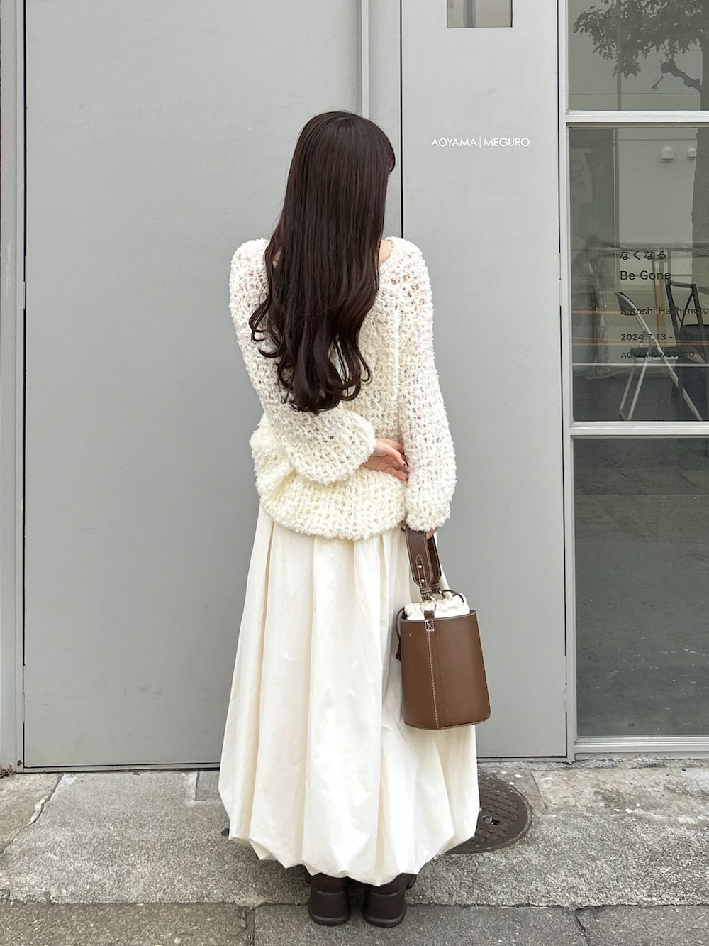 ブラウン系のハンドバッグ、ホワイト系のワンピース、ホワイト系のスカートを着用したレディースの秋コーディネートの4枚目の写真