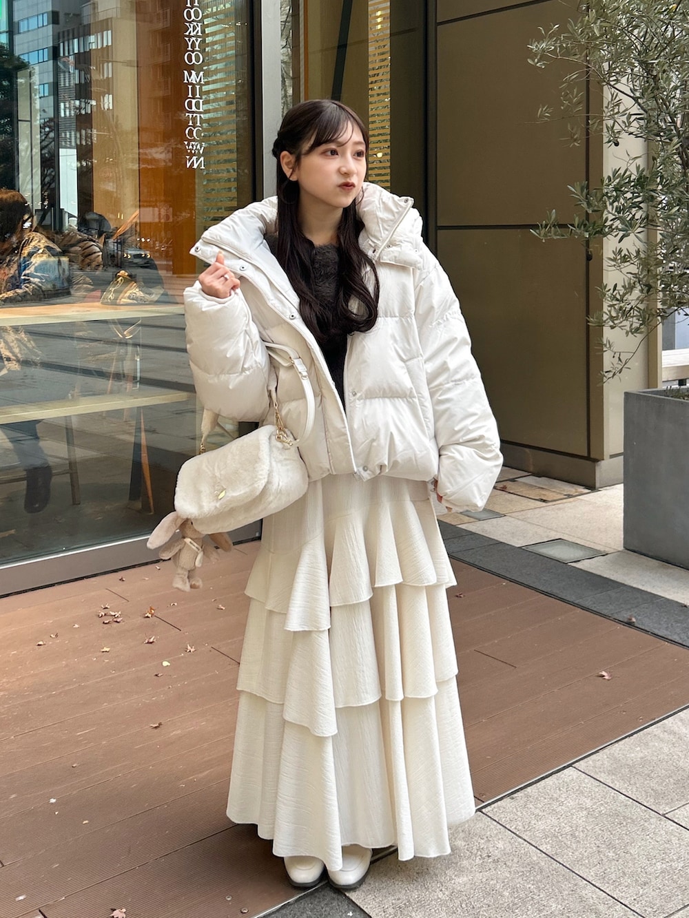 ホワイト系のショルダーバッグ、ピンク系のワンピース、ブラウン系のカーディガン/ボレロを着用したレディースの冬コーディネートの5枚目の写真