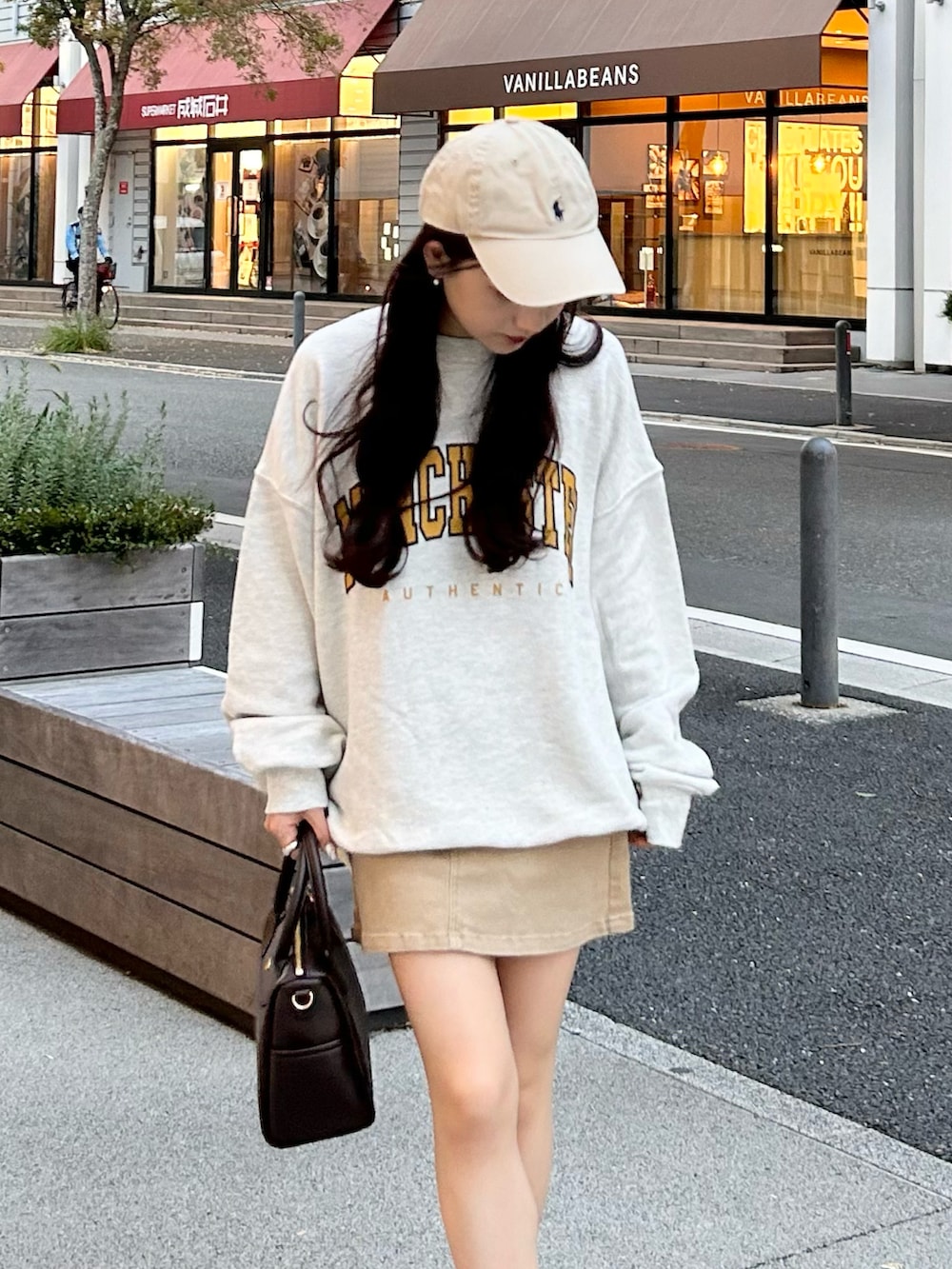 ベージュ系のデニムスカート、ベージュ系のスウェット、グレー系のスニーカーを着用したレディースの秋コーディネートの3枚目の写真