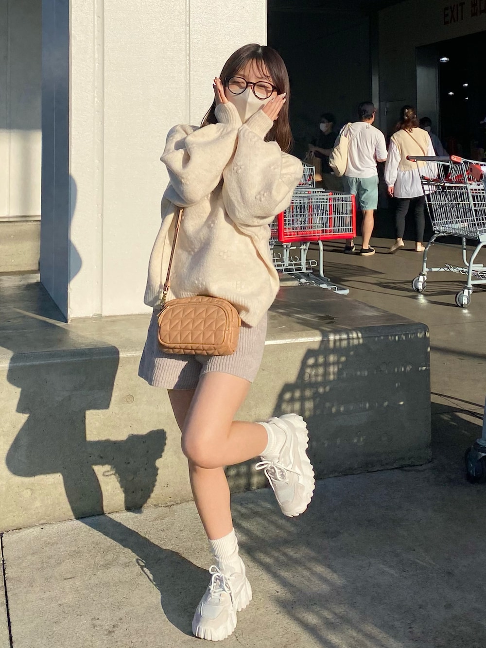 ホワイト系のスニーカー、ホワイト系のニット/セーター、ベージュ系のパンツを着用したレディースの秋コーディネートの2枚目の写真