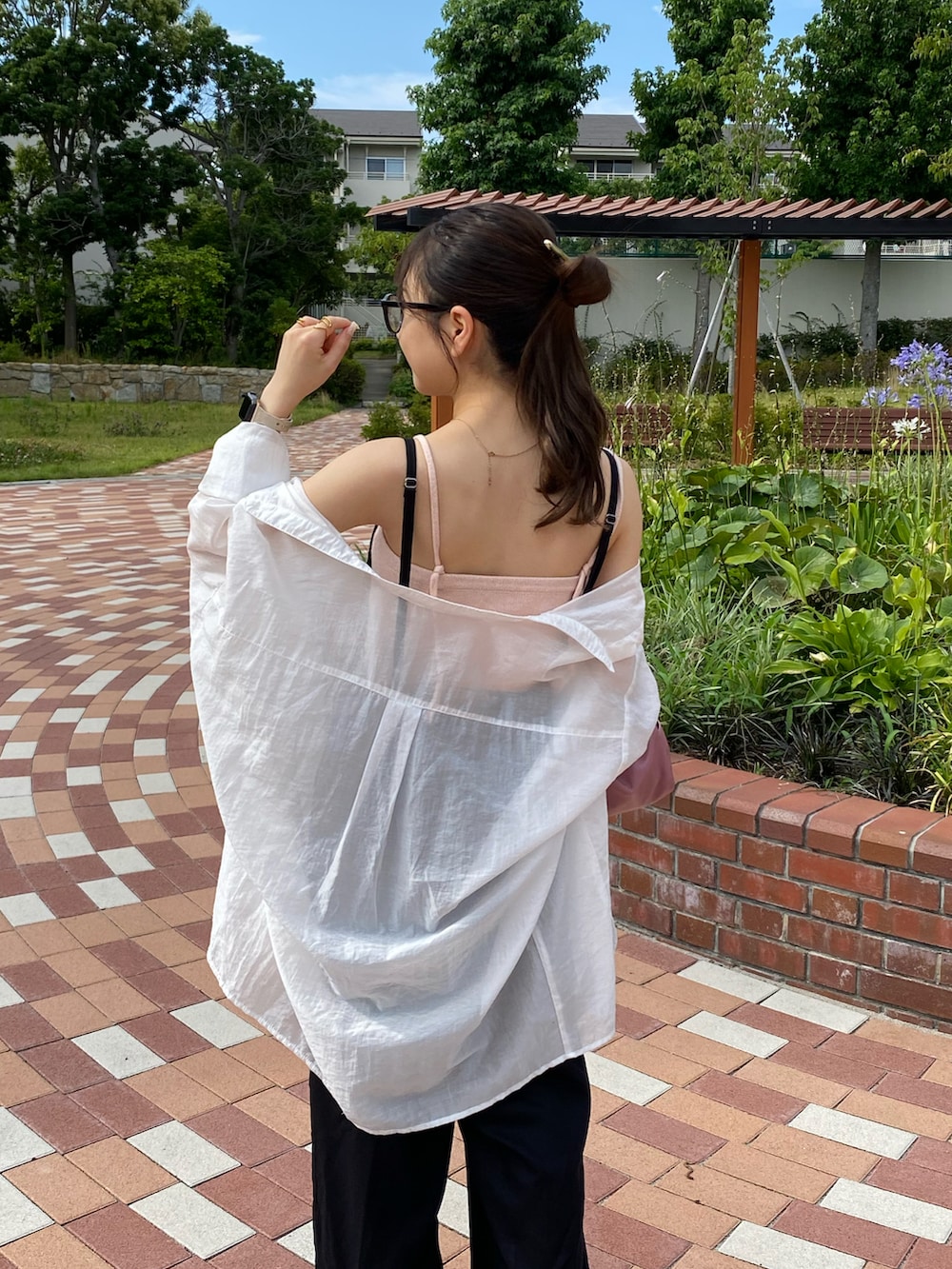 ピンク系のボストンバッグ、ホワイト系のシャツ/ブラウス、ホワイト系のサンダルを着用したレディースの夏コーディネートの3枚目の写真