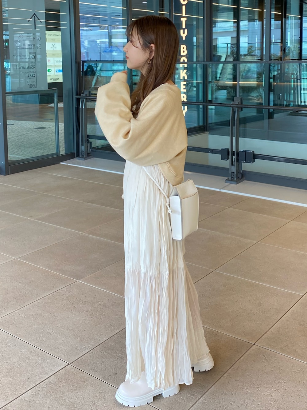 ホワイト系のワンピース、ホワイト系のカーディガン/ボレロ、ホワイト系のショルダーバッグを着用したレディースの春コーディネートの2枚目の写真