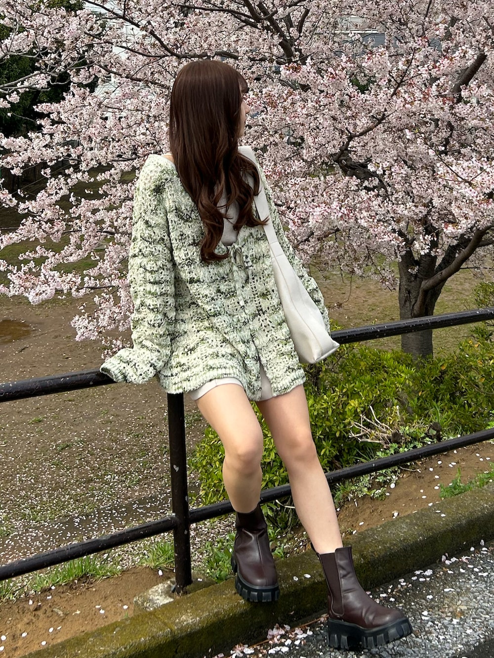 ホワイト系のトートバッグ、ホワイト系のその他パンツ、ブラウン系のブーツを着用したレディースの春コーディネートの3枚目の写真