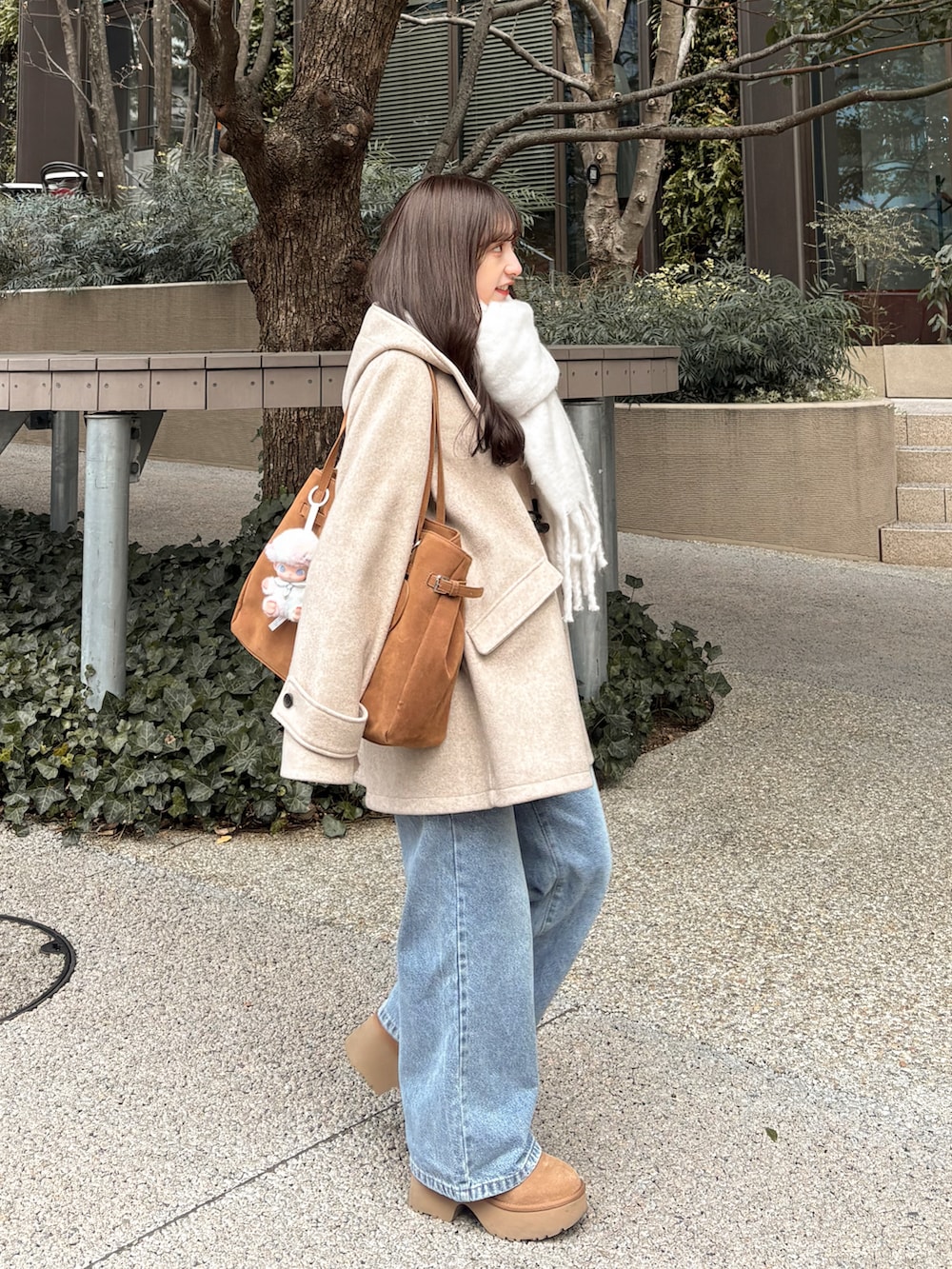 ブルー系のデニムパンツ、ベージュ系のその他アウター、ベージュ系のブーツを着用したレディースの冬コーディネートの4枚目の写真