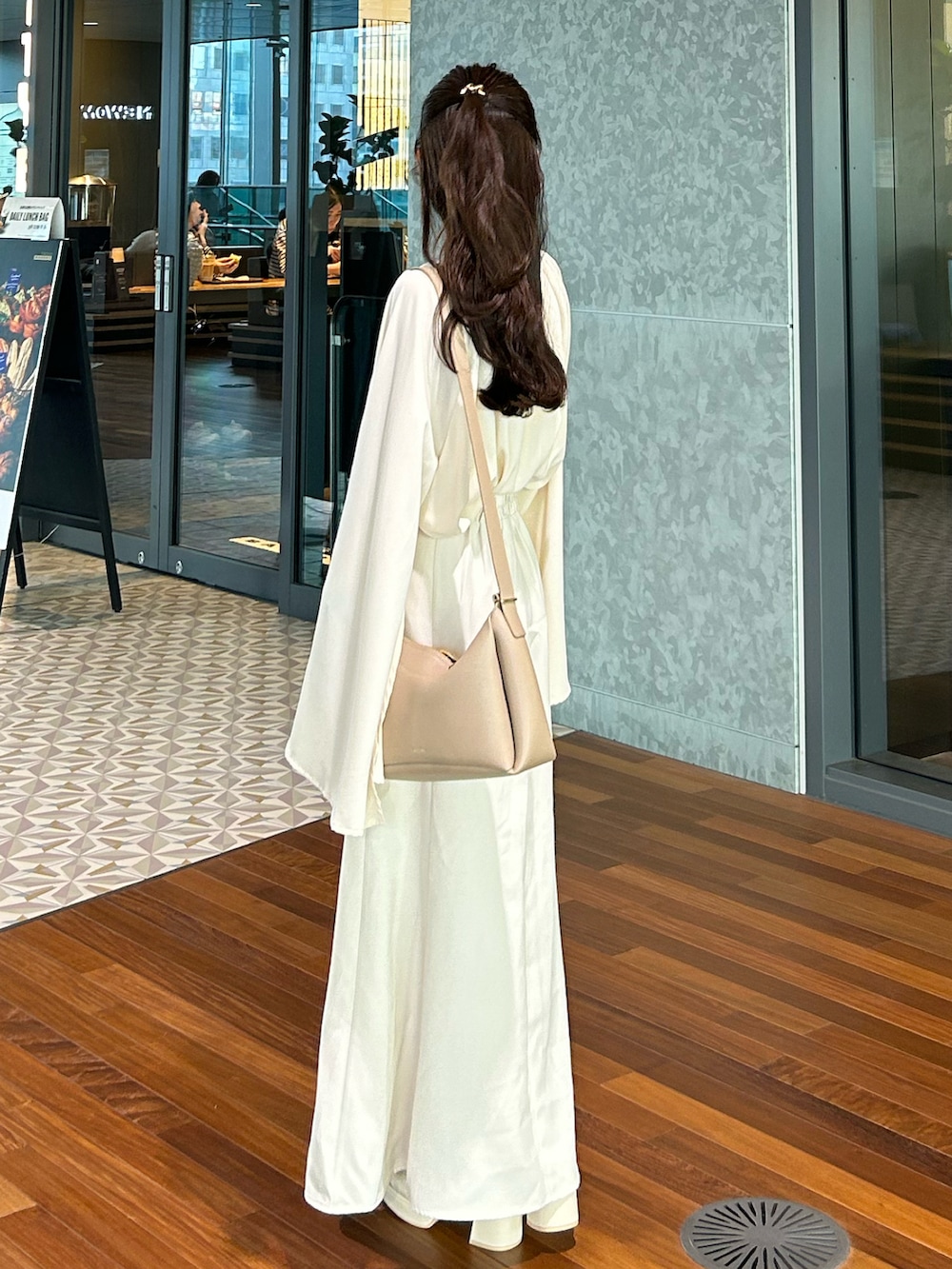 ホワイト系のスカート、ベージュ系のシャツ/ブラウス、ホワイト系のサンダルを着用したレディースの春コーディネートの2枚目の写真