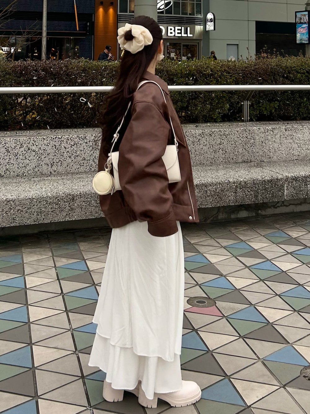 ブラウン系のブルゾン、ホワイト系のワンピース、ホワイト系のショルダーバッグを着用したレディースの春コーディネートの2枚目の写真