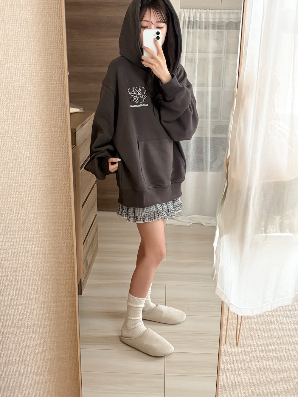 ブラック系のデニムパンツ、ホワイト系のショルダーバッグ、ピンク系のスニーカーを着用したレディースの秋コーディネートの4枚目の写真