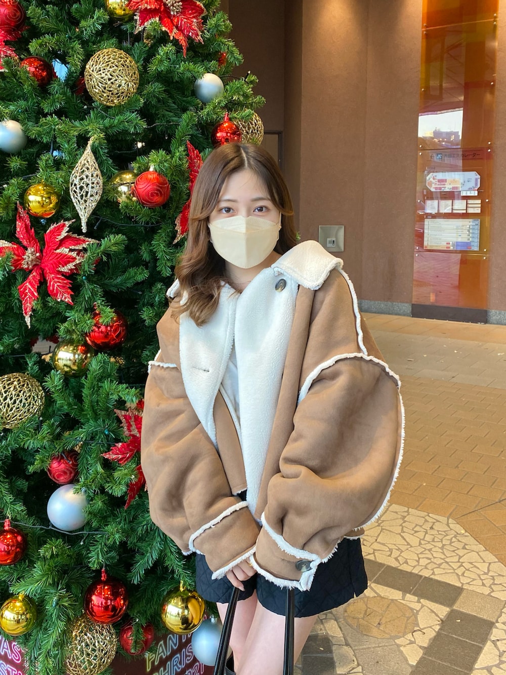 ブラック系のパンツ、ブラック系のハンドバッグ、ブラック系のブーツを着用したレディースの秋コーディネートの2枚目の写真