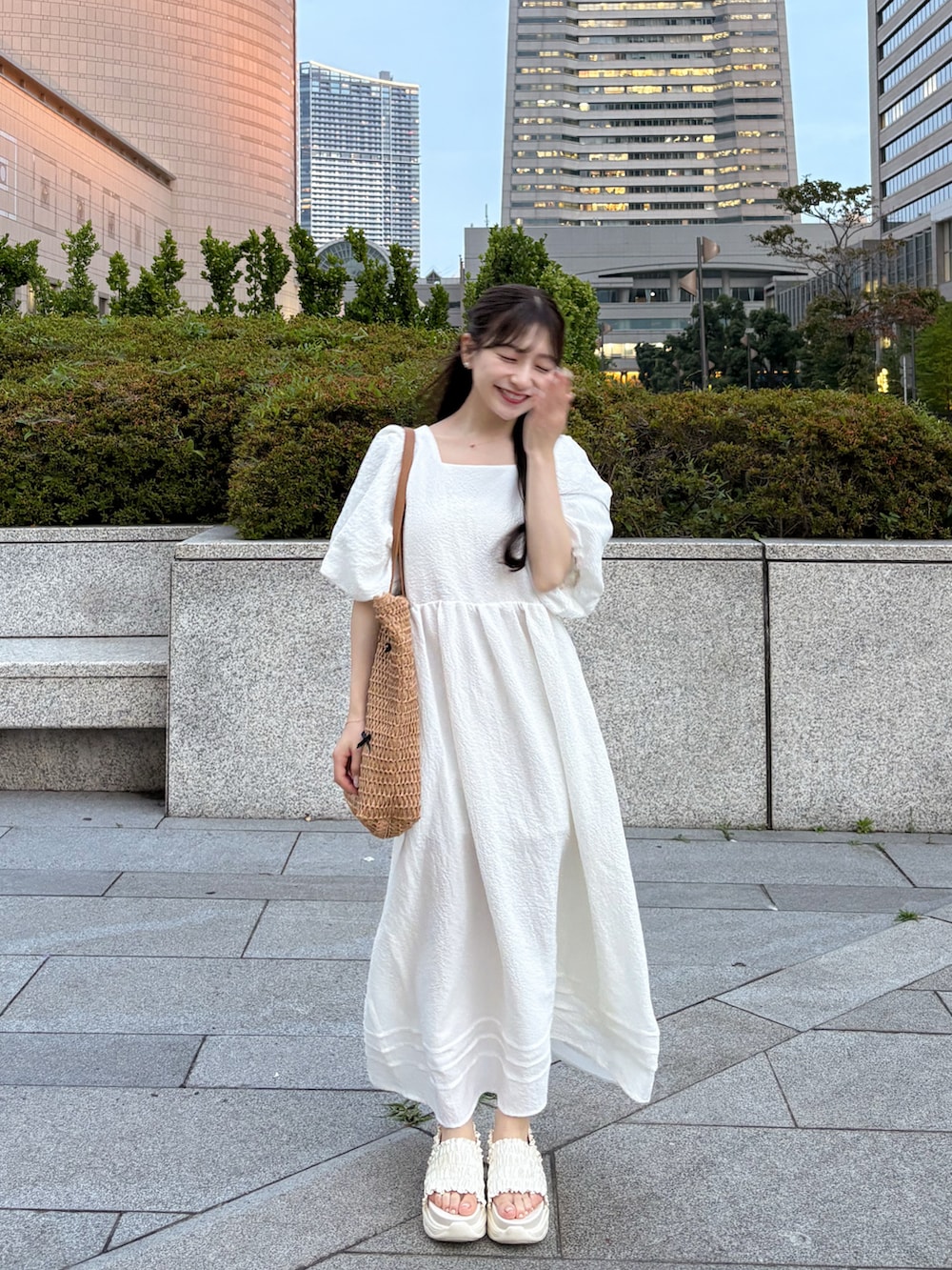 ホワイト系のサンダル、ベージュ系のワンピース、ベージュ系のトートバッグを着用したレディースの夏コーディネートの5枚目の写真