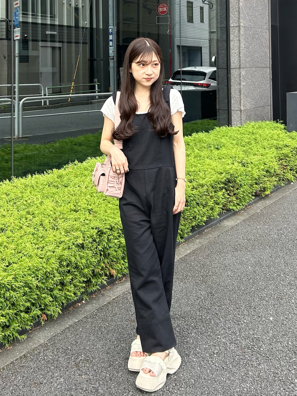 ホワイト系のサンダル、ブラック系のサロペット/オーバーオール、ピンク系のショルダーバッグを着用したレディースの夏コーディネートの3枚目の写真