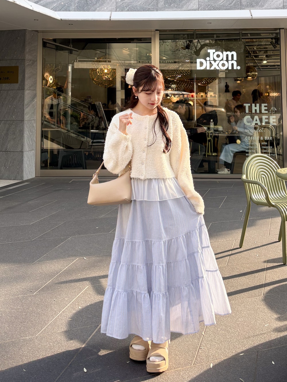 ホワイト系のトレンチコート、ホワイト系のカーディガン/ボレロ、ブルー系のスカートを着用したレディースの春コーディネートの3枚目の写真