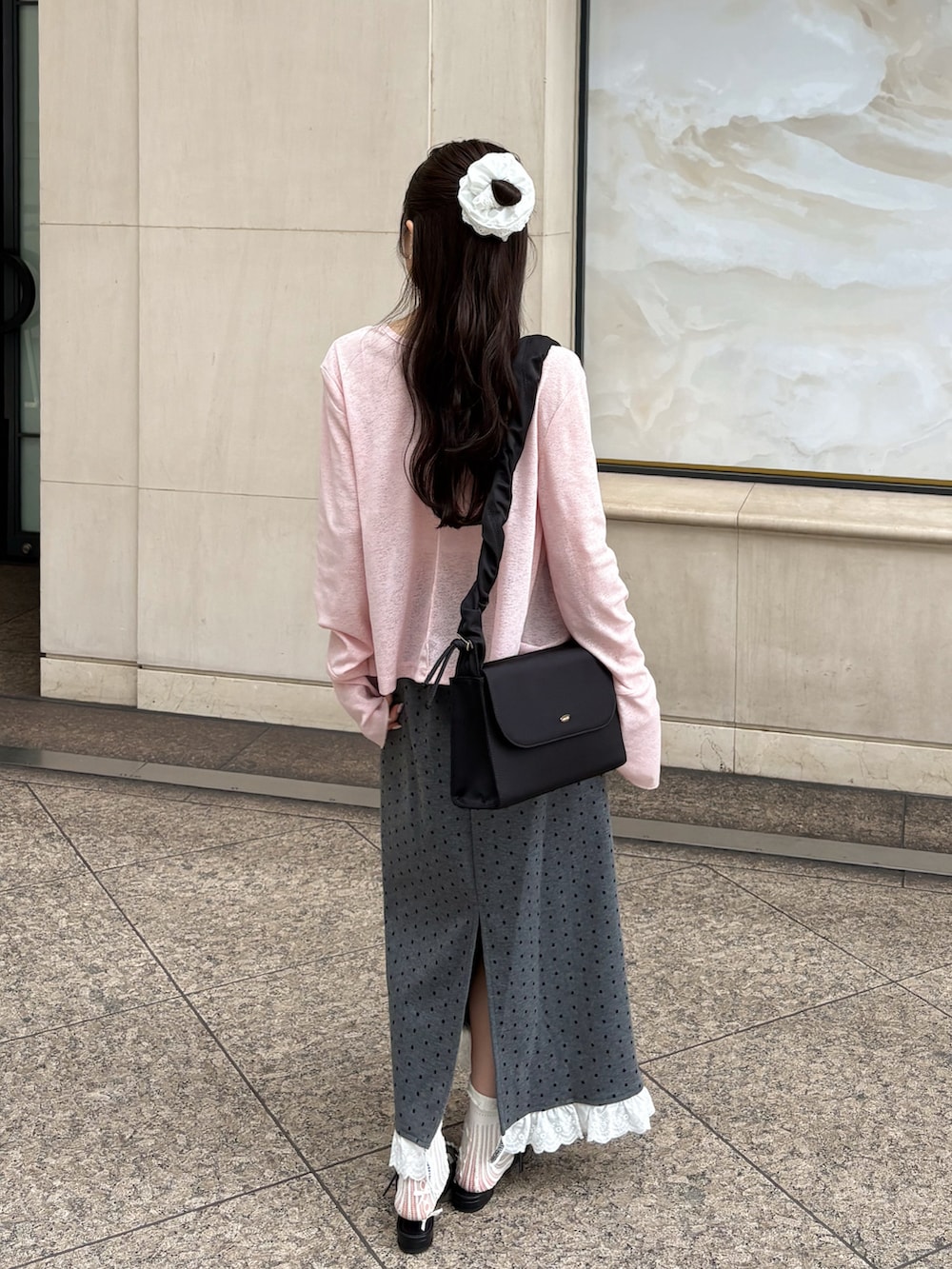 ブラック系のバッグ、ピンク系のカーディガン/ボレロ、ホワイト系のキャミソールを着用したレディースの夏コーディネートの3枚目の写真