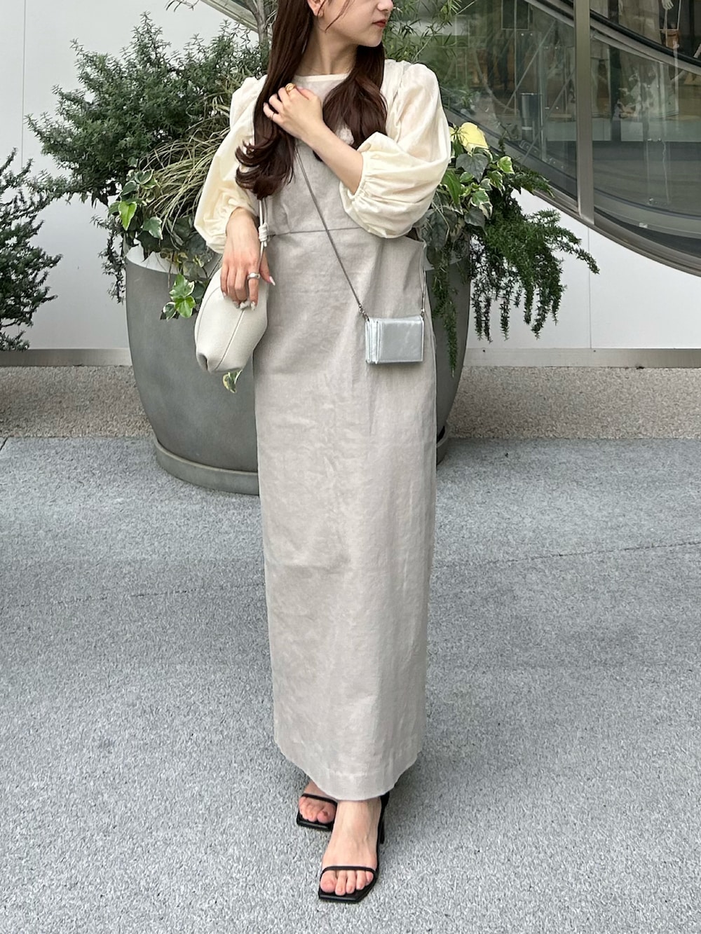 グレー系のワンピース、シルバー系のショルダーバッグ、ブラック系のサンダルを着用したレディースの夏コーディネートの2枚目の写真