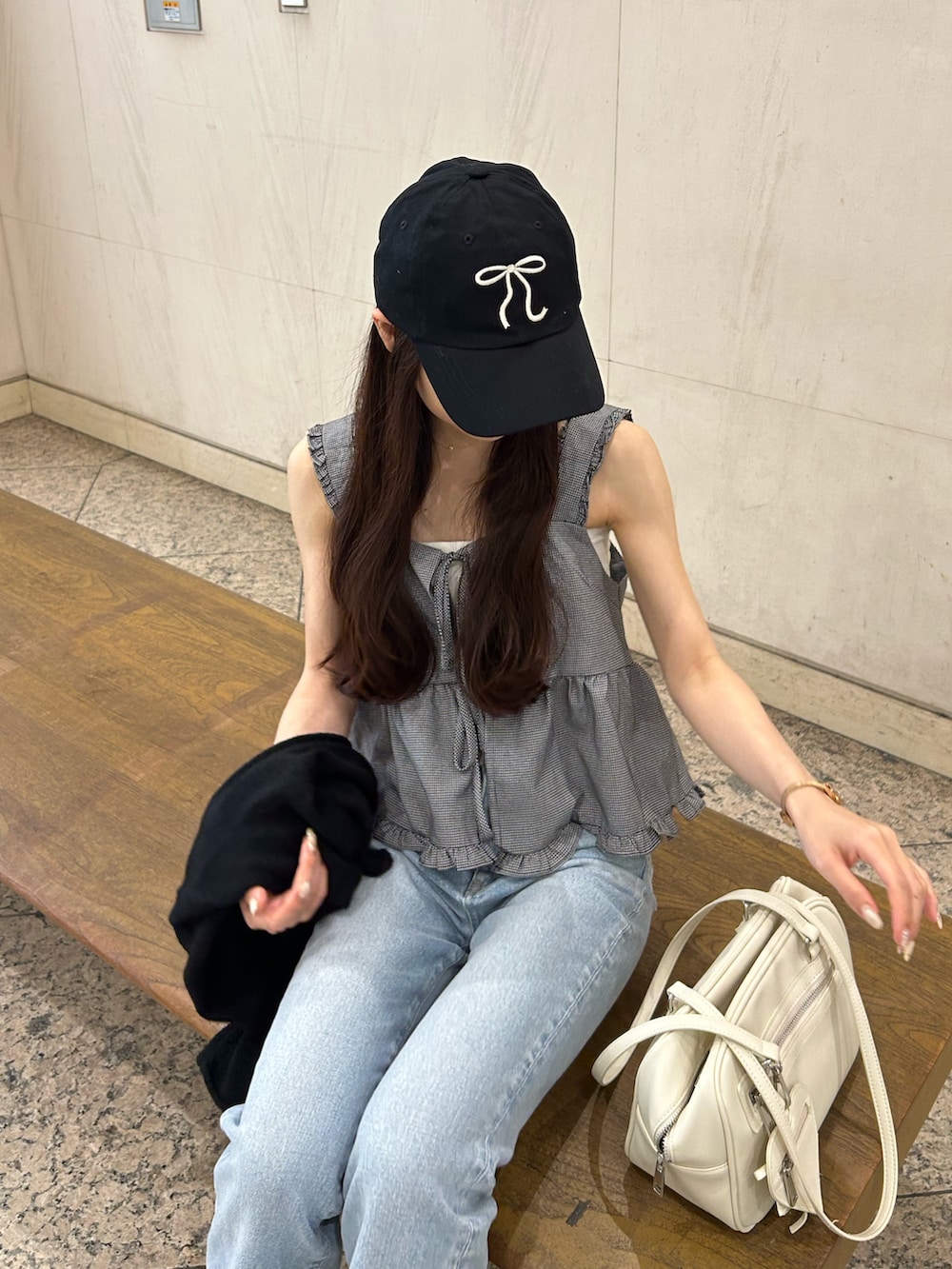 ブルー系のデニムパンツ、ホワイト系のショルダーバッグ、ベージュ系のサンダルを着用したレディースの夏コーディネートの3枚目の写真