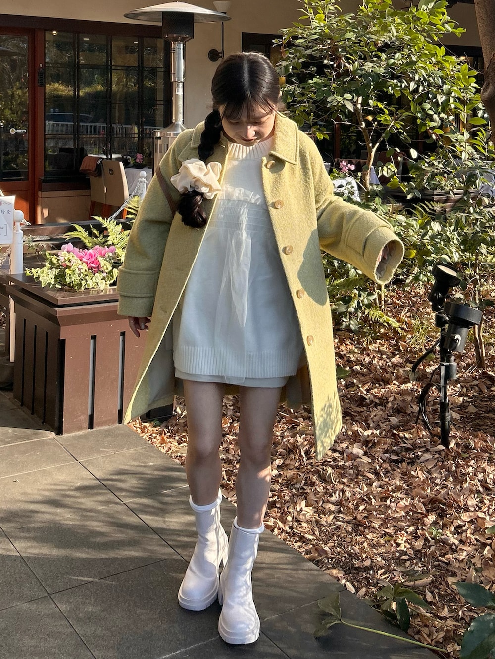 ホワイト系のニット/セーター、ブラウン系のバッグ、ホワイト系のスカートを着用したレディースの冬コーディネートの3枚目の写真