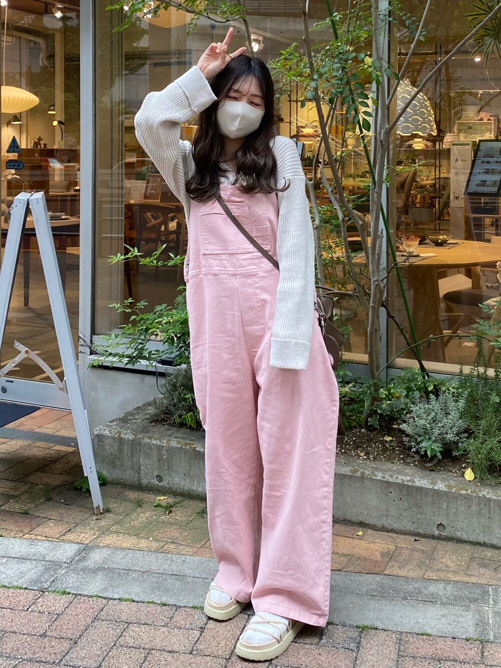 ベージュ系のサンダル、ピンク系のサロペット/オーバーオール、ホワイト系のカーディガン/ボレロを着用したレディースの春コーディネートの2枚目の写真