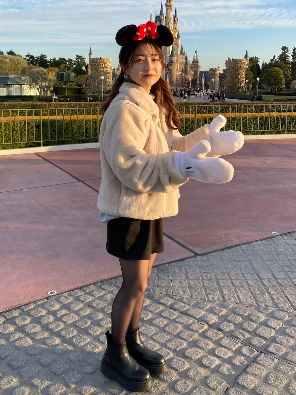 ホワイト系のジャケット/アウター、ブラック系のスカート、ブラック系のブーツを着用したレディースの春コーディネートの2枚目の写真