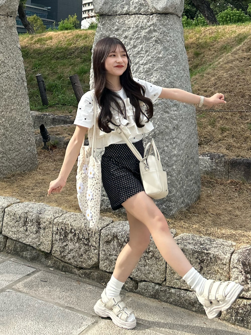 ホワイト系のサンダル、ホワイト系のTシャツ/カットソー、ホワイト系のショルダーバッグを着用したレディースの夏コーディネートの2枚目の写真
