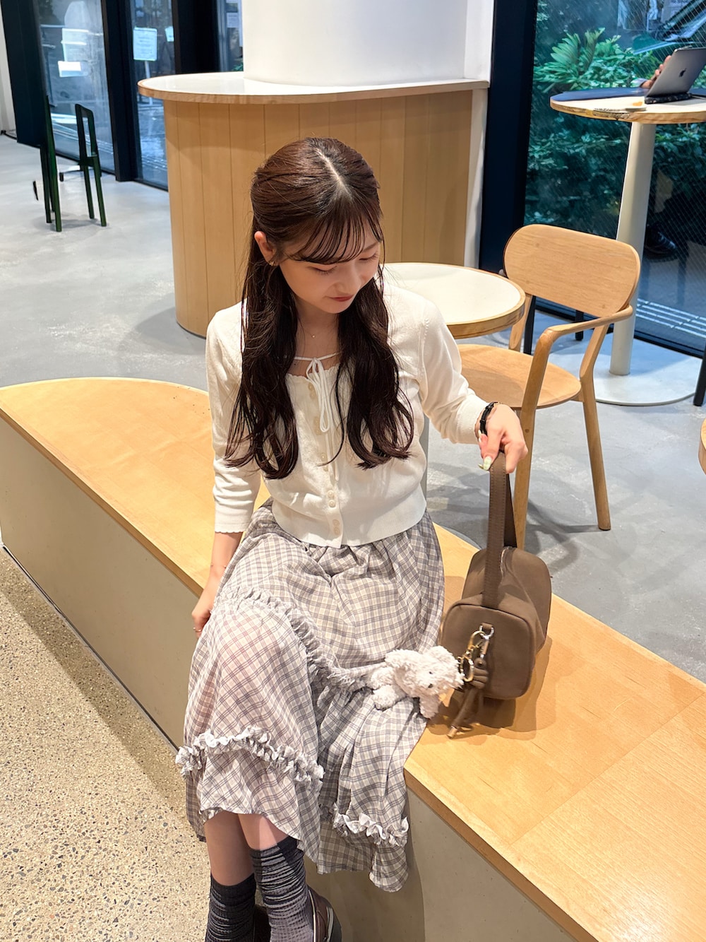 ホワイト系のカーディガン/ボレロ、ベージュ系のスカート、ブラウン系のショルダーバッグを着用したレディースの秋コーディネートの4枚目の写真