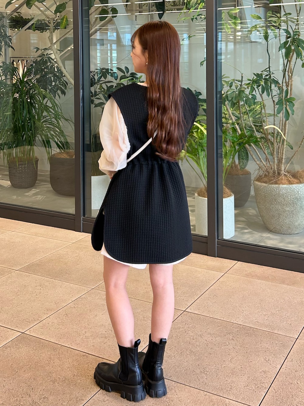 ブラック系のベスト、ベージュ系のシャツ/ブラウス、ベージュ系のショルダーバッグを着用したレディースの春コーディネートの3枚目の写真