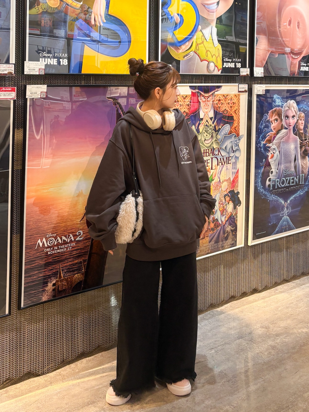 ブラック系のデニムパンツ、ホワイト系のショルダーバッグ、ピンク系のスニーカーを着用したレディースの秋コーディネートの3枚目の写真