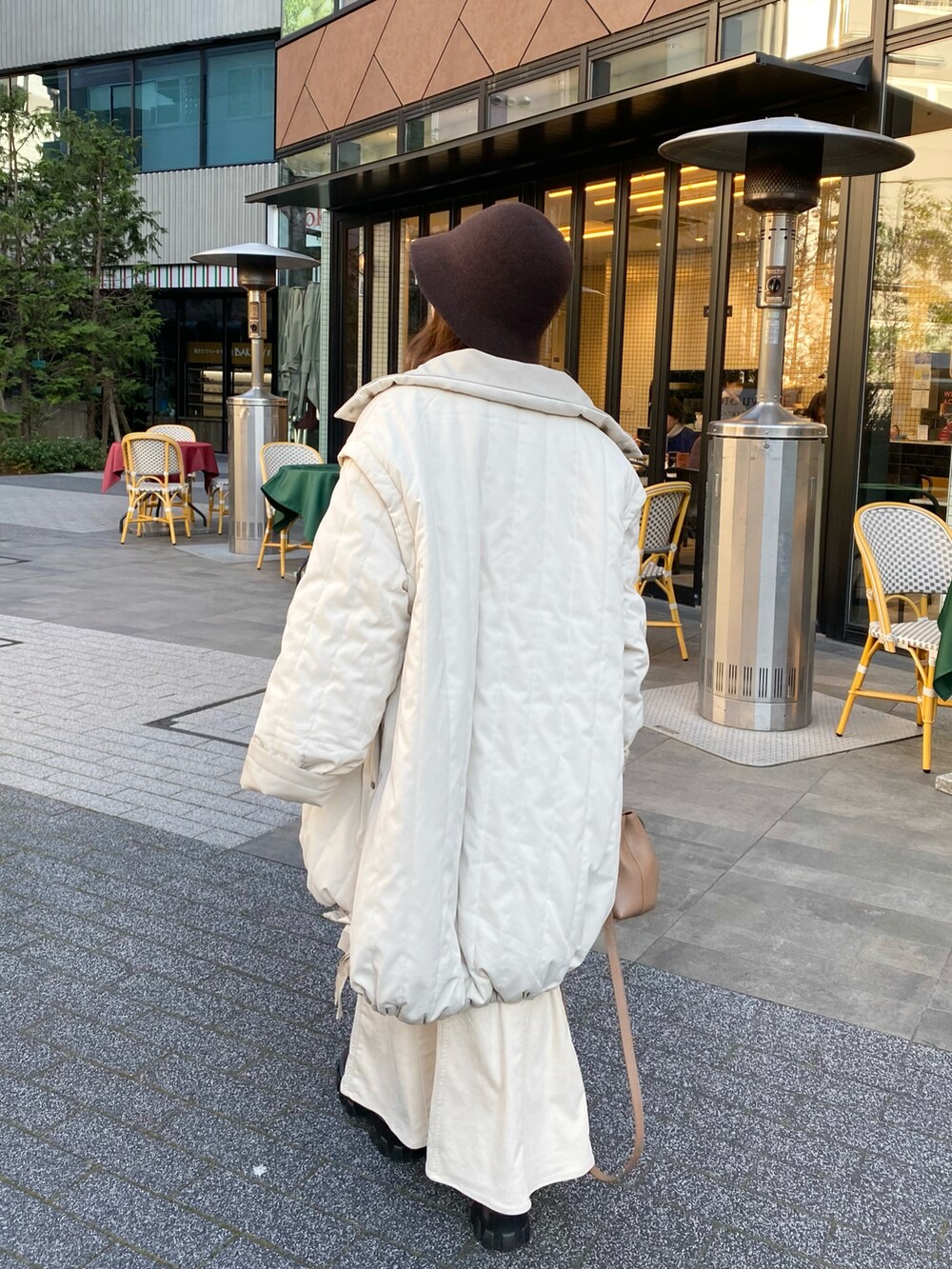 ホワイト系のダウンジャケット/コート、ブラウン系のバッグ、ブラウン系のブーツを着用したレディースの冬コーディネートの4枚目の写真