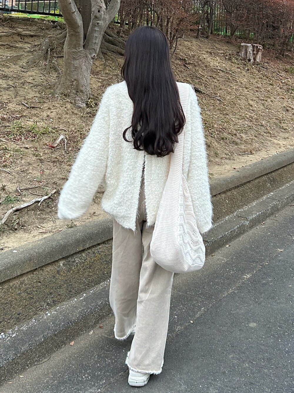 ベージュ系のデニムパンツ、ホワイト系のダッフルコート、ホワイト系のカーディガン/ボレロを着用したレディースの冬コーディネートの4枚目の写真