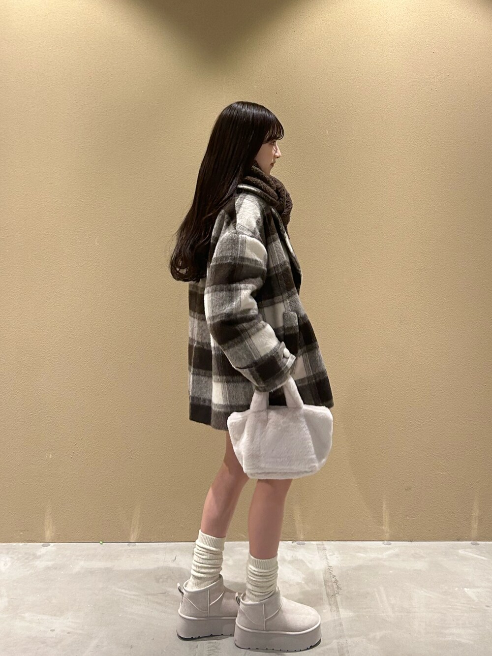 ブラウン系のジャケット/アウター、ホワイト系のバッグ、ホワイト系のブーツを着用したレディースの冬コーディネートの3枚目の写真