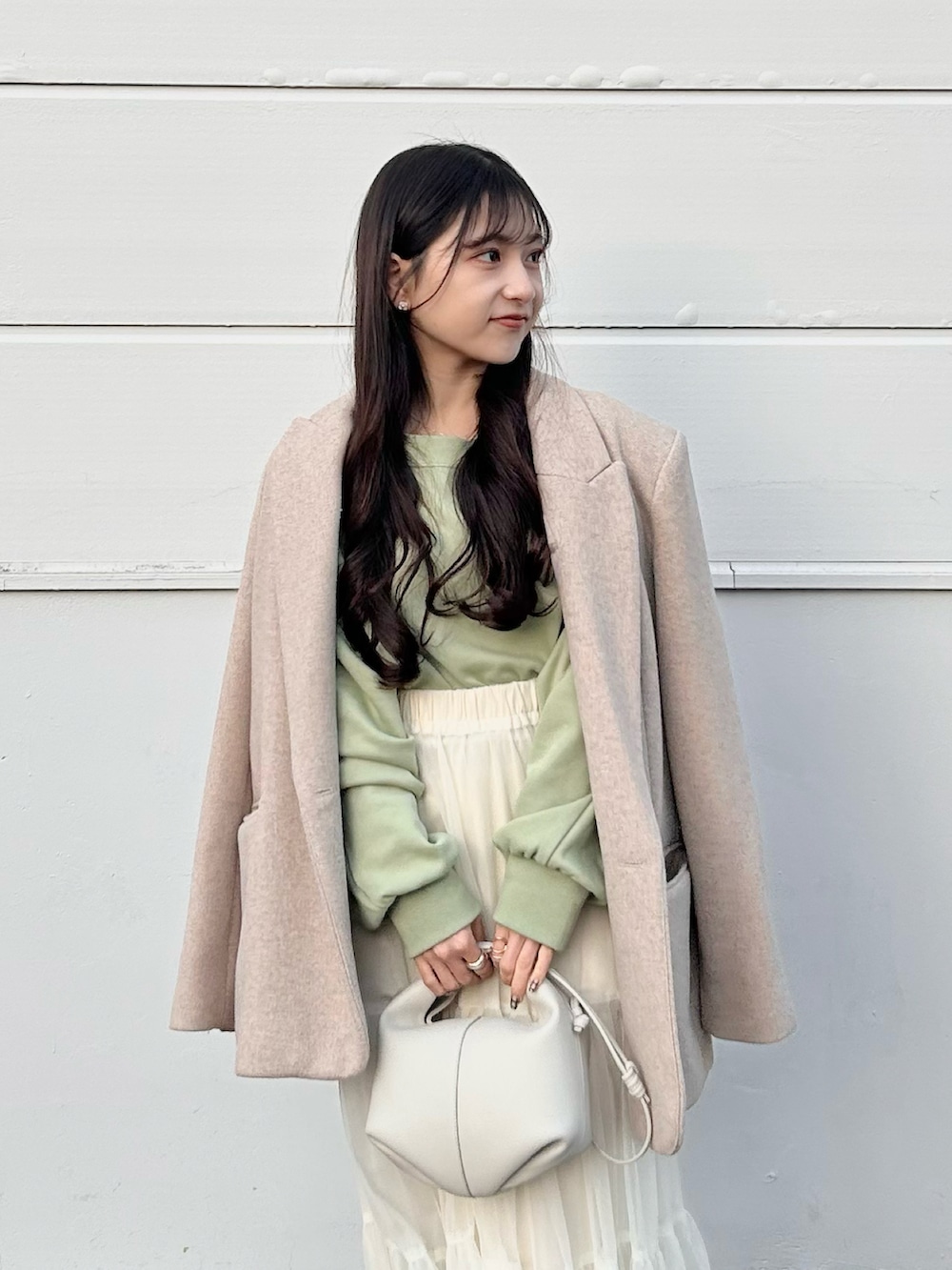 ベージュ系のジャケット/アウター、グリーン系のスウェット、ホワイト系のスカートを着用したレディースの冬コーディネートの4枚目の写真