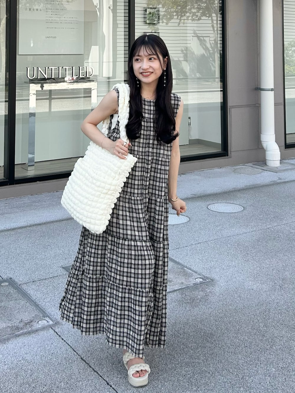 ホワイト系のサンダル、ブラック系のワンピース/ドレス、ホワイト系のトートバッグを着用したレディースの夏コーディネートの3枚目の写真