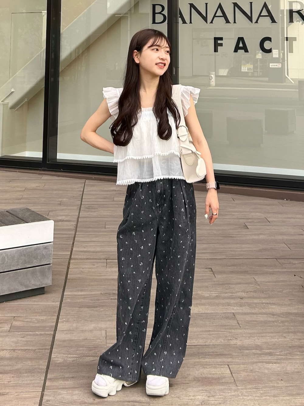 ブラック系のデニムパンツ、ホワイト系のキャミソール、ホワイト系のショルダーバッグを着用したレディースの春コーディネートの2枚目の写真