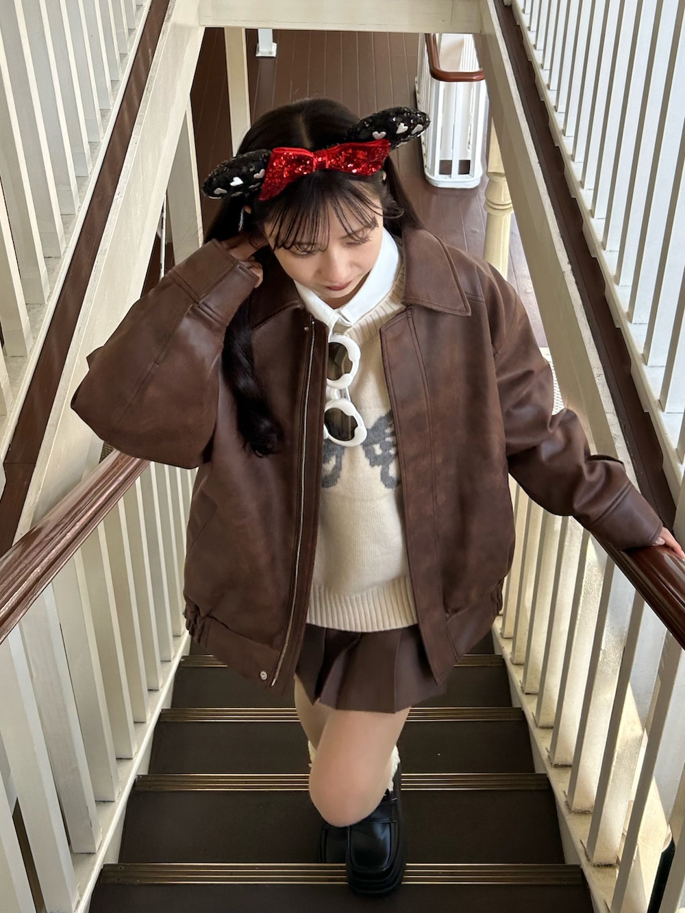 ホワイト系のニット/セーター、ブラウン系のスカート、ブラウン系のブルゾンを着用したレディースの冬コーディネートの2枚目の写真