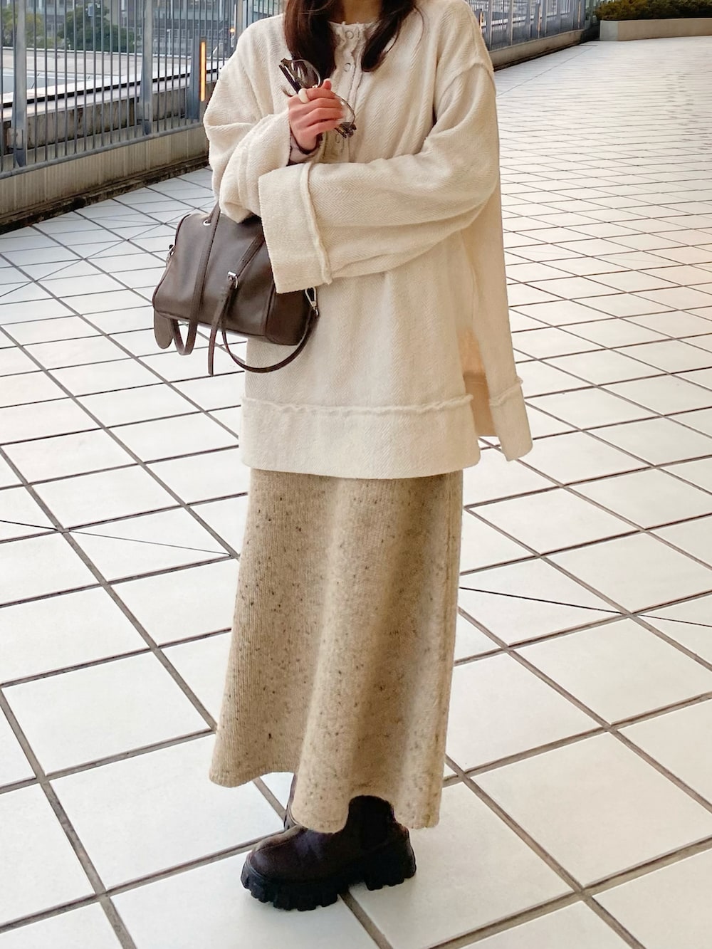 ホワイト系のダウンジャケット/コート、ベージュ系のショルダーバッグ、ホワイト系のTシャツ/カットソーを着用したレディースの冬コーディネートの3枚目の写真