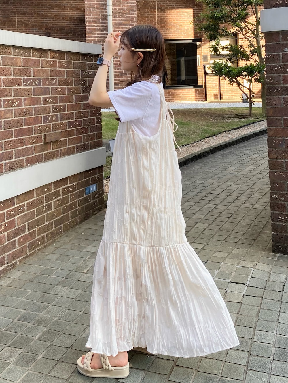 ホワイト系のサンダル、ブラック系のバッグ、ホワイト系のワンピースを着用したレディースの夏コーディネートの3枚目の写真