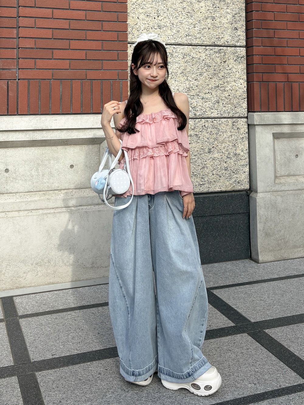 ブルー系のデニムパンツ、ホワイト系のトップス、ホワイト系のスニーカーを着用したレディースの夏コーディネートの5枚目の写真