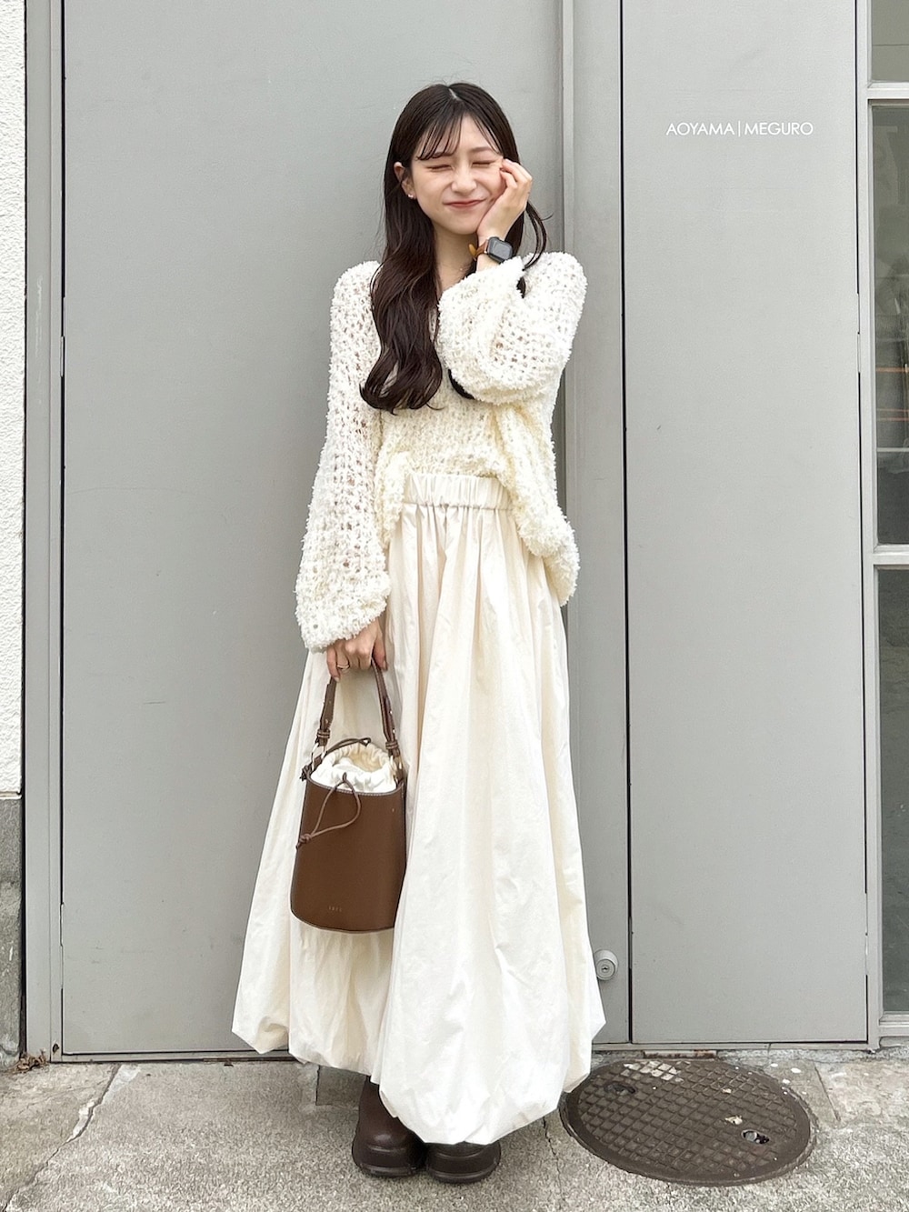 ブラウン系のハンドバッグ、ホワイト系のワンピース、ホワイト系のスカートを着用したレディースの秋コーディネートの2枚目の写真