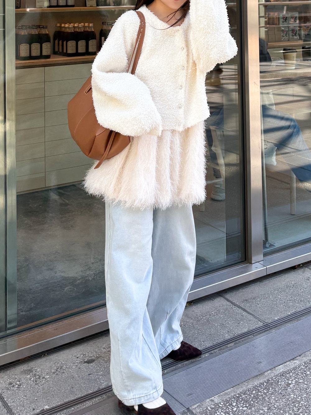 ホワイト系のキャミソール、ホワイト系のカーディガン/ボレロ、ブルー系のデニムパンツを着用したレディースの春コーディネートの2枚目の写真