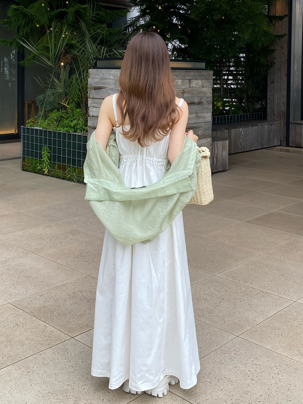 ホワイト系のワンピース、ベージュ系のかごバッグ、グリーン系のシャツ/ブラウスを着用したレディースの夏コーディネートの4枚目の写真