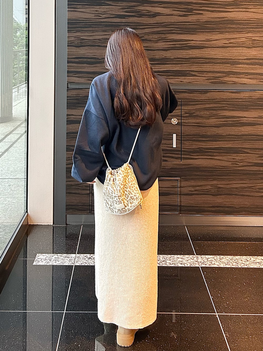 ホワイト系のスカート、ブルー系のスウェット、ベージュ系のショルダーバッグを着用したレディースの秋コーディネートの3枚目の写真