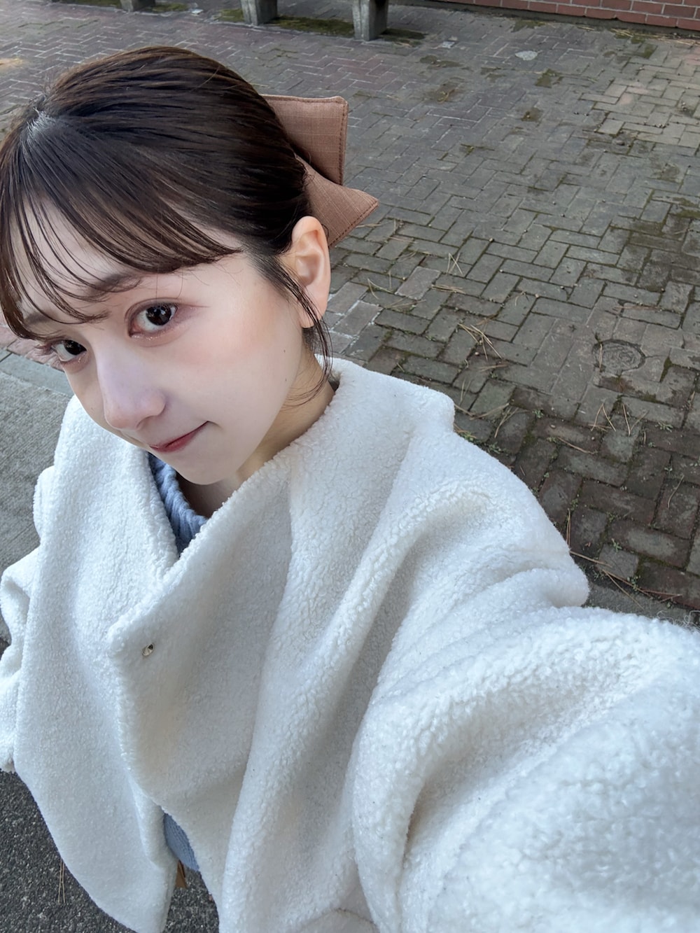 グレー系のスウェットパンツ、ホワイト系のブルゾン、ブルー系のニット/セーターを着用したレディースの冬コーディネートの4枚目の写真